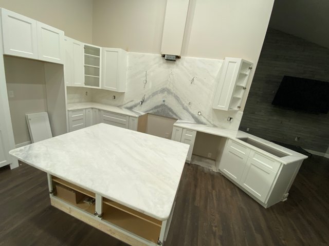 Kitchen installation with island and full-height backsplash